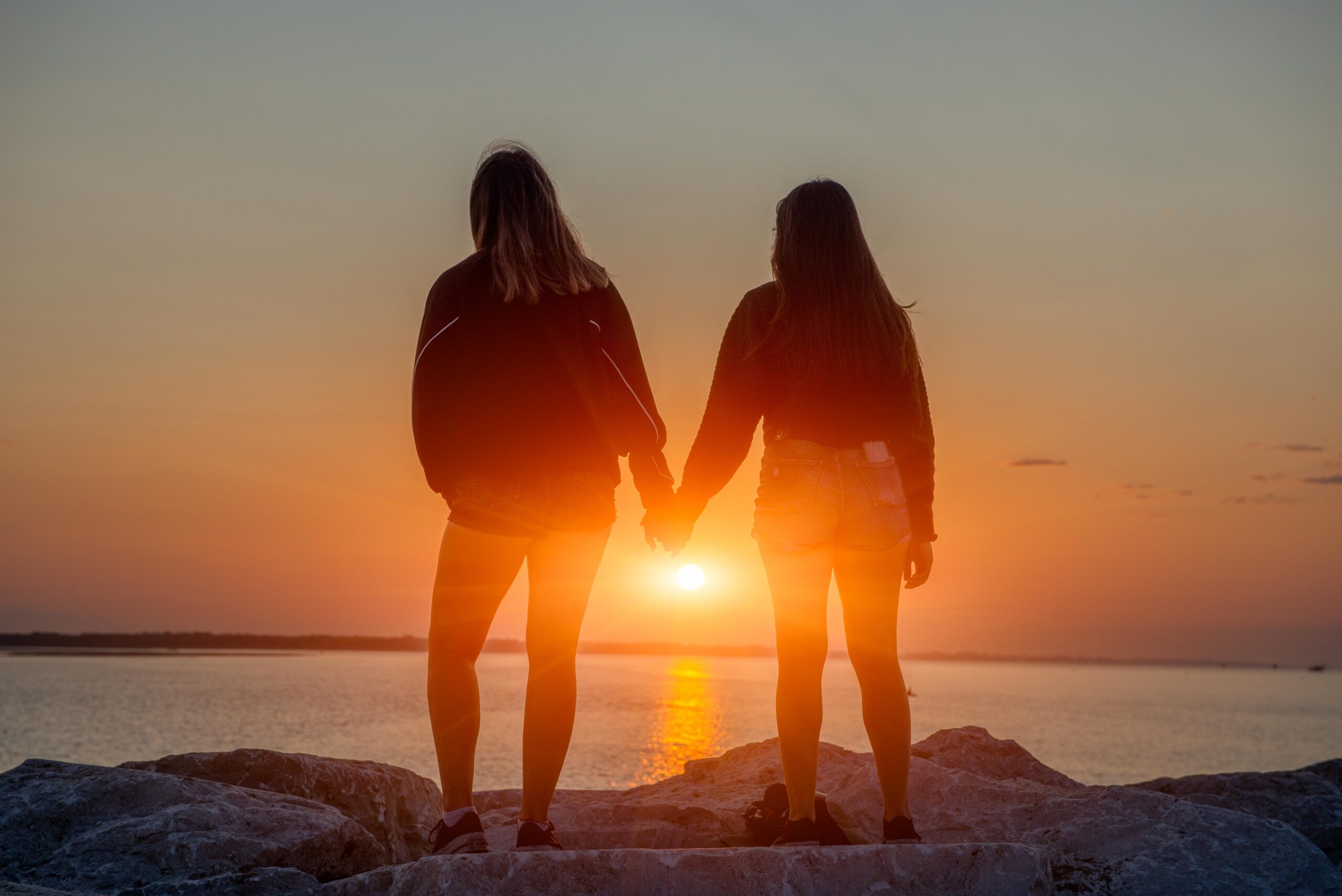 girls by the sea at sunrise